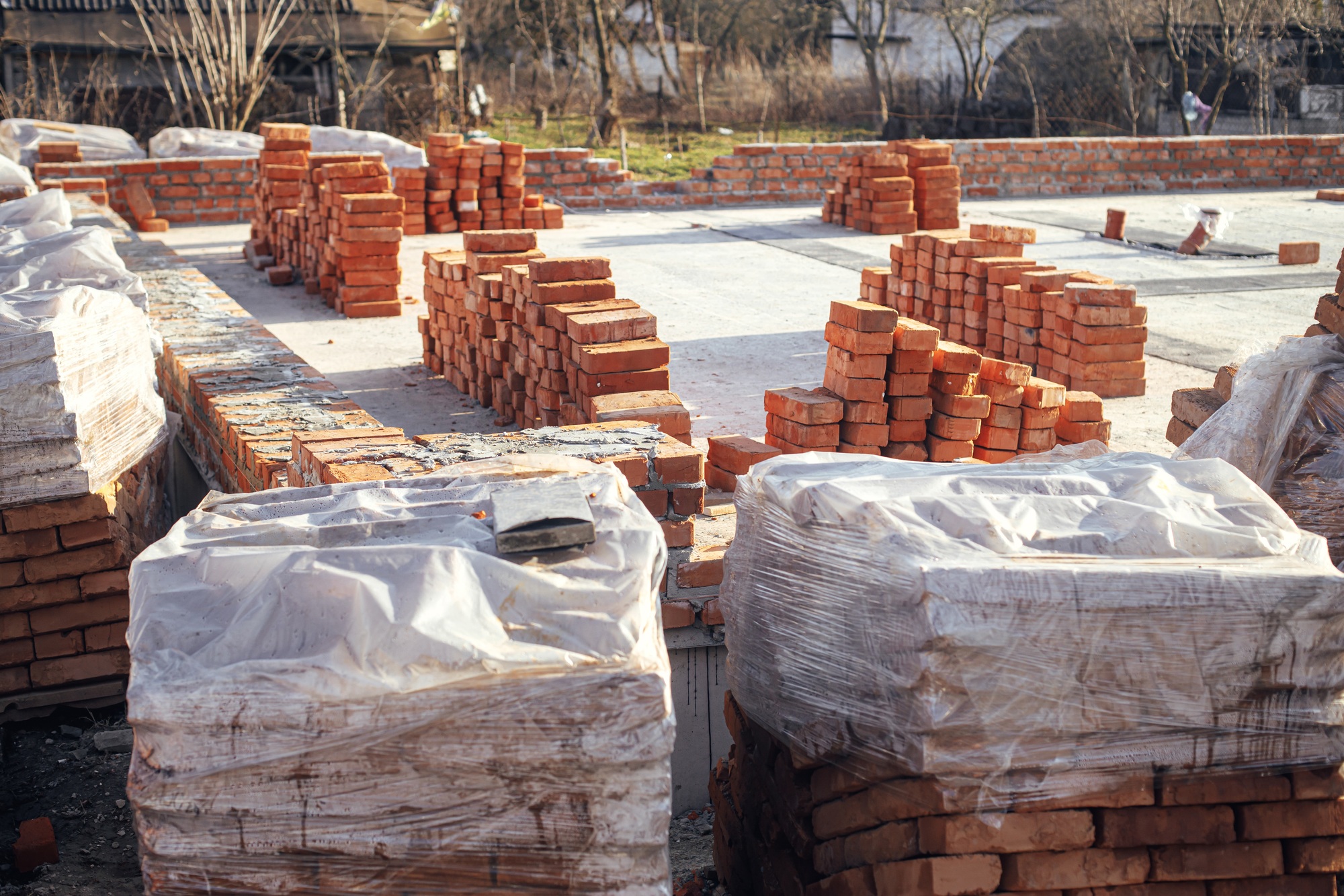 Concrete foundation with bricks for laying. Building materials at construction site